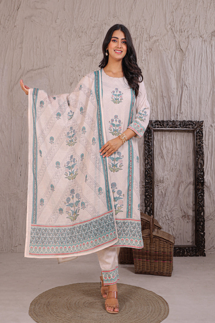 Woman holding a floral-patterned dupatta against a textured wall.