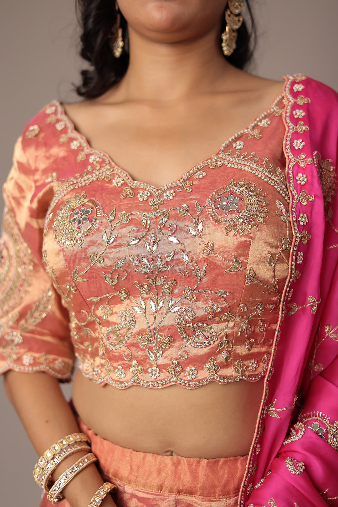 Peach Shimmer Tissue Lehenga with Intricate Gota Patti, Pearl & Zardozi Embellishments Paired with a Contrasting Pink Dupatta