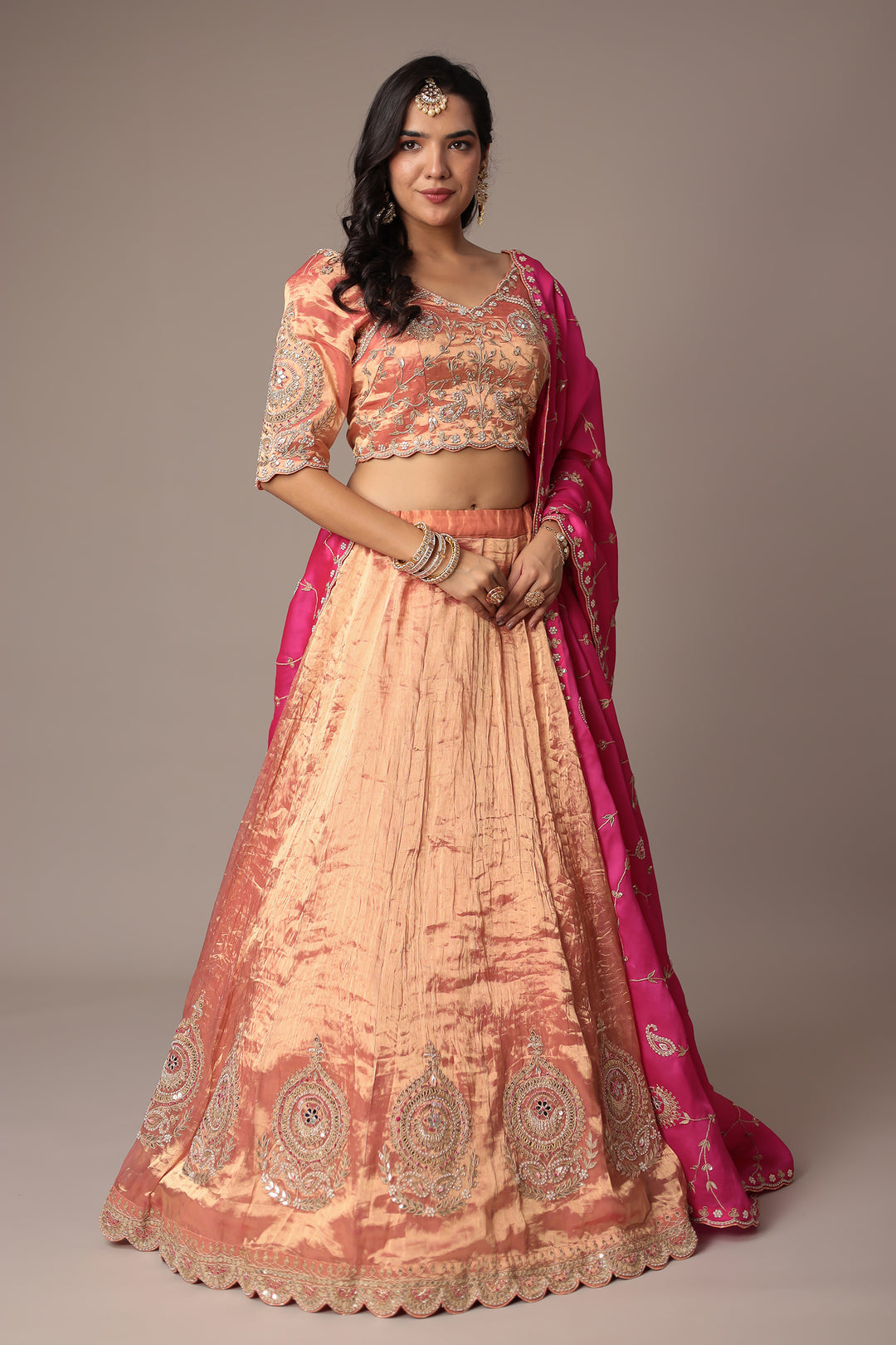 Peach Shimmer Tissue Lehenga with Intricate Gota Patti, Pearl & Zardozi Embellishments Paired with a Contrasting Pink Dupatta