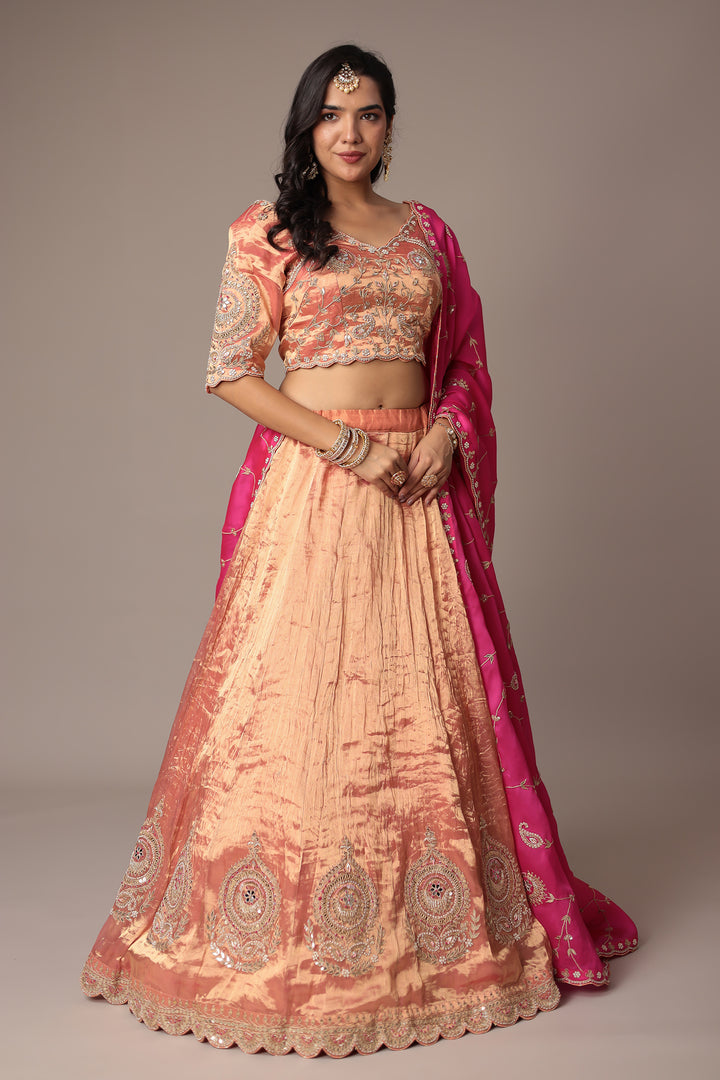 Peach Shimmer Tissue Lehenga with Intricate Gota Patti, Pearl & Zardozi Embellishments Paired with a Contrasting Pink Dupatta