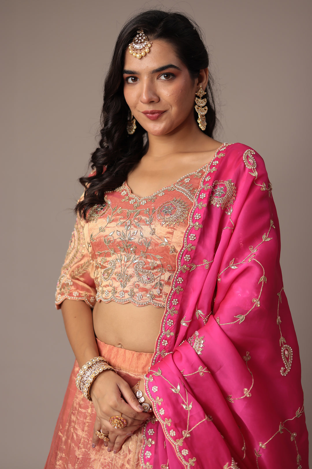 Peach Shimmer Tissue Lehenga with Intricate Gota Patti, Pearl & Zardozi Embellishments Paired with a Contrasting Pink Dupatta