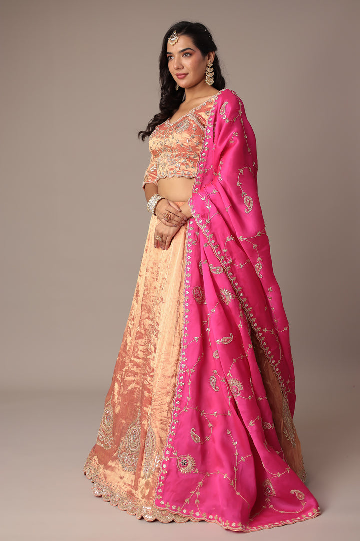 Peach Shimmer Tissue Lehenga with Intricate Gota Patti, Pearl & Zardozi Embellishments Paired with a Contrasting Pink Dupatta