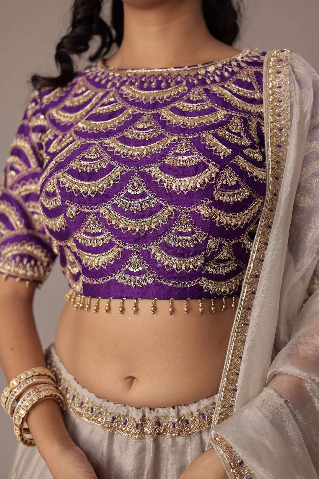 Ivory Shimmer Tissue Lehenga with Intricate Aari, Pearl, Thread & Zardozi Embroidery Paired with a Royal Purple Blouse