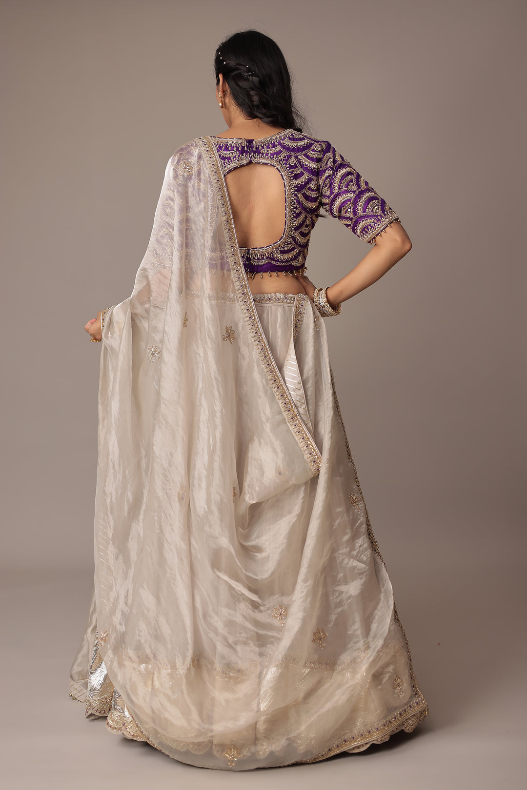 Ivory Shimmer Tissue Lehenga with Intricate Aari, Pearl, Thread & Zardozi Embroidery Paired with a Royal Purple Blouse