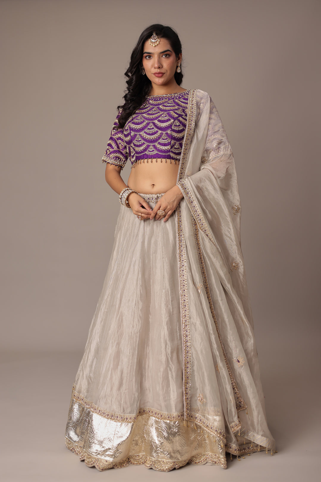 Ivory Shimmer Tissue Lehenga with Intricate Aari, Pearl, Thread & Zardozi Embroidery Paired with a Royal Purple Blouse