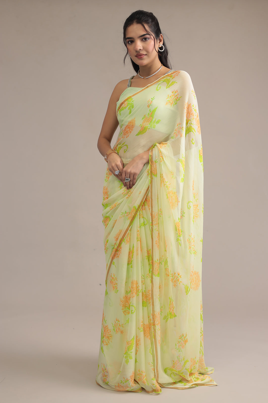 Woman wearing a light green saree with floral patterns