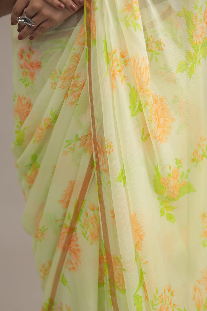 Light green saree with floral patterns on a plain background